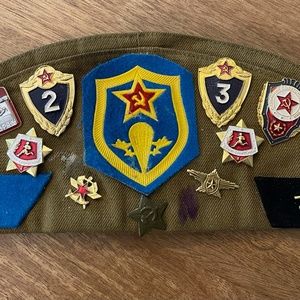 Vintage Cold War Russian hat with 13 metal badges